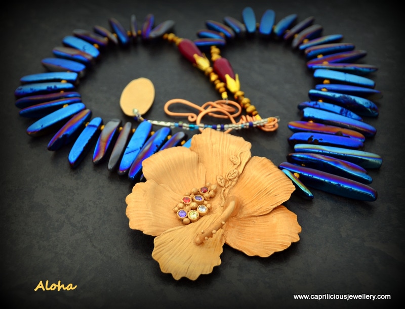 Aloha - hibiscus bronze clay flower on a necklace of quartz needles, electroplated with titanium by Caprilicious Jewellery