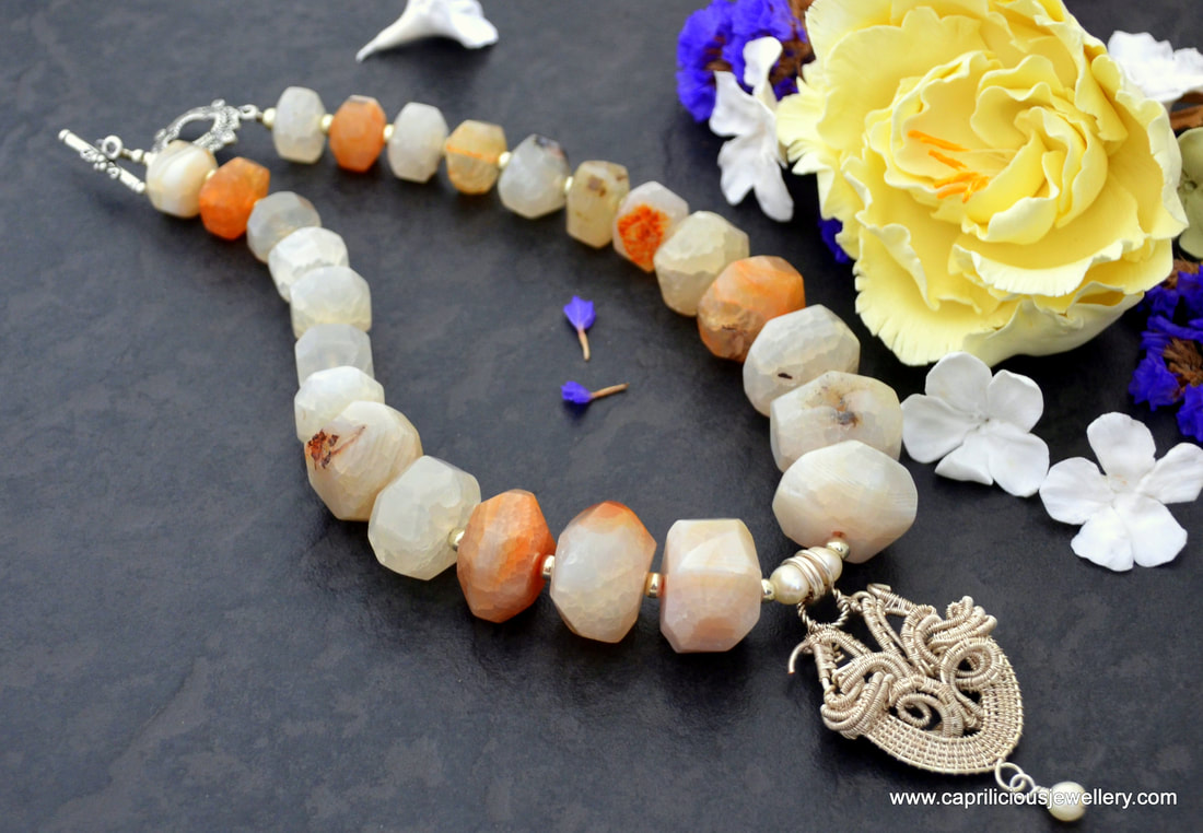 Necklace of agate nugget beads with wire work pendant