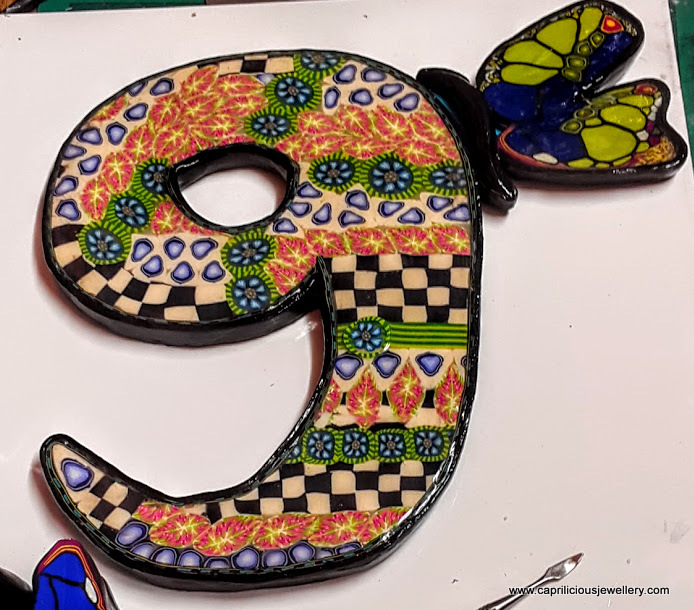 Door number with polymer clay canes and a butterfly cane by Caprilicious Jewellery