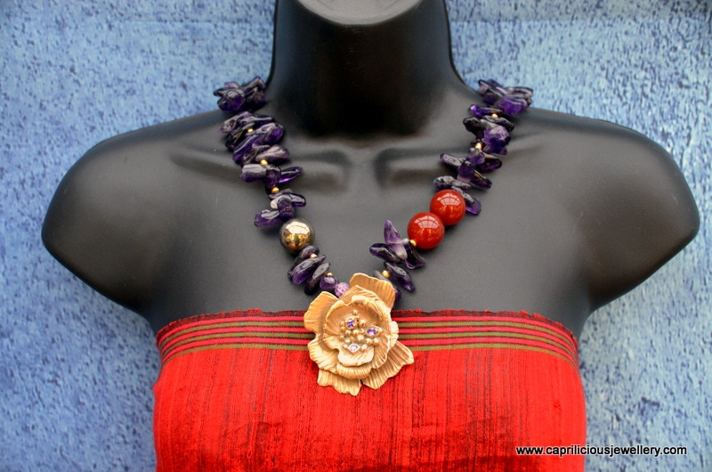 PictBronze clay flower with cubic zirconium, on an amethyst necklace with carnelian and pyrite accents and andmade clasp by Caprilicious Jewelleryure