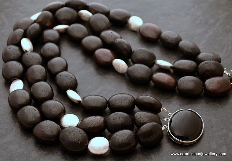 Black ceramic beads in a multistrand necklace by Caprilicious Jewellery
