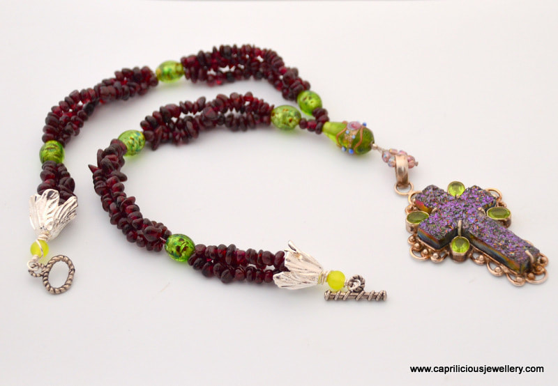 Gothic garnet necklace with a titanium druzy and peridot cross by Caprilicious Jewellery
